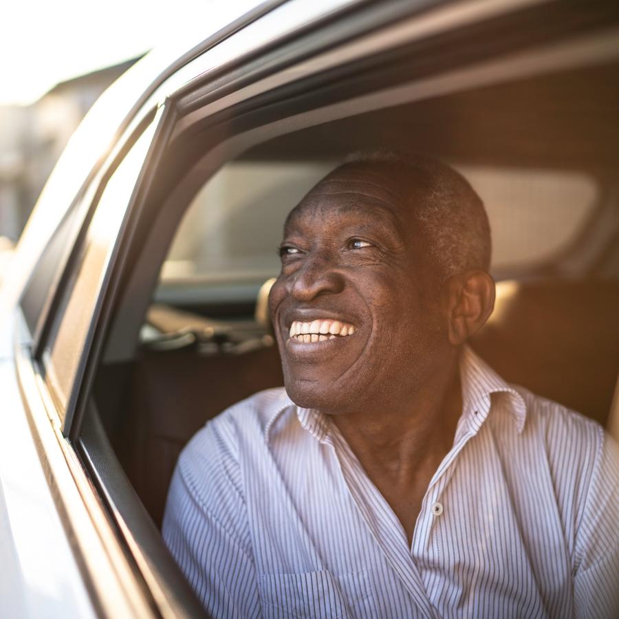 man smiling out car window