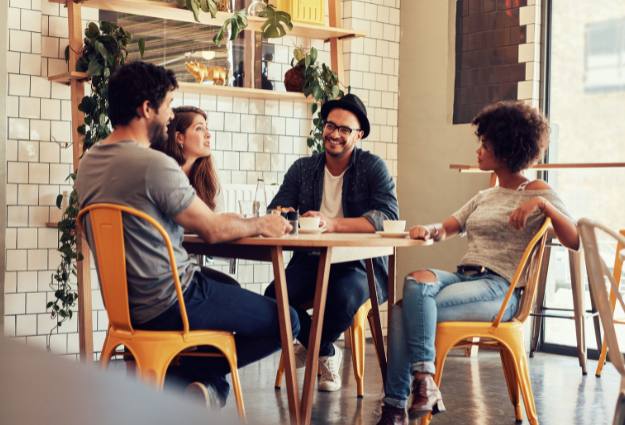 group of friends smiling at a cafe