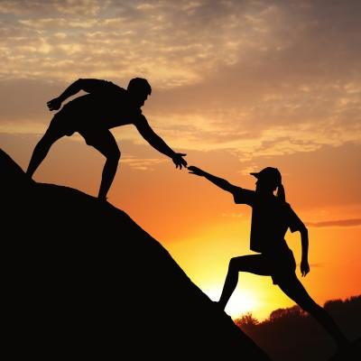 man helping a woman up a hill