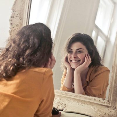 woman smiling into mirror