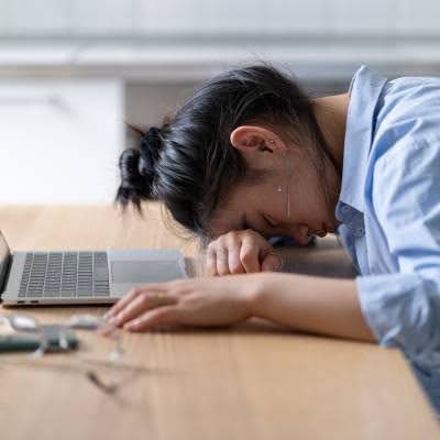 woman with head down on desk