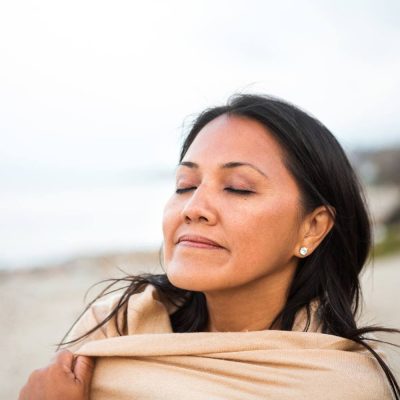 woman wrapped in blanket at beach